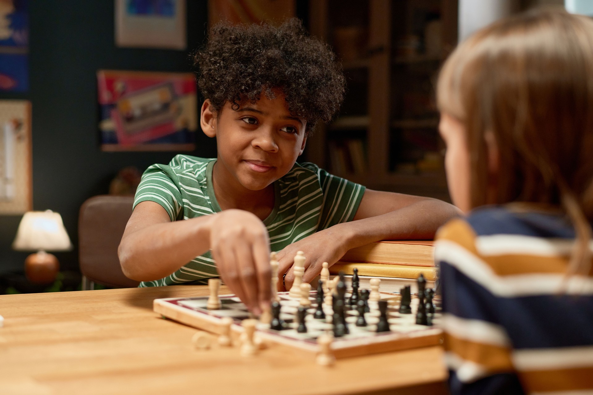 Boy moving chess figurine on board