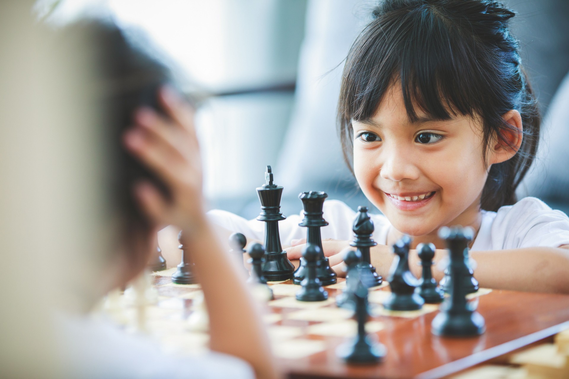 close up asian girl are playing at a chess table